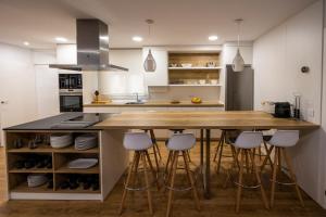 a kitchen with a wooden table and bar stools at El balcón del Poeta in El Burgo de Osma
