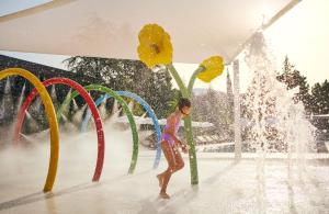 un niño parado frente a una fuente con flores en Bluesun Holiday Village Bonaca - Full Board Plus, en Bol