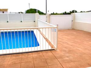 a swimming pool behind a white fence on a patio at 4 bed house, Private Pool near Beach in Burriana
