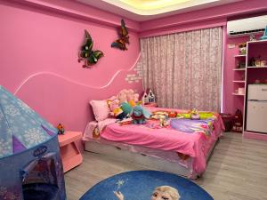 Kenting Mola في نانوان: غرفة نوم وردية مع سرير مع دمى عليه
