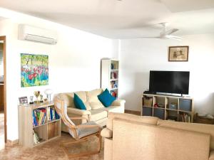 - un salon avec un canapé et une télévision dans l'établissement 4 bed house, Private Pool near Beach, à Burriana