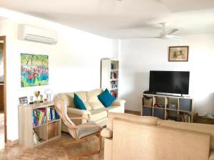 a living room with a couch and a tv at 4 bed house, Private Pool near Beach in Burriana