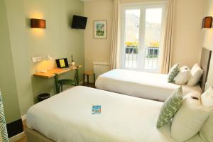 Cama ou camas em um quarto em Logis Hôtels- Hôtel Marguerite d'Anjou Angers château