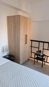 1 dormitorio con 1 cama y armario de madera en Pagani Green - Luxury Maisonette I2, en Kalamata
