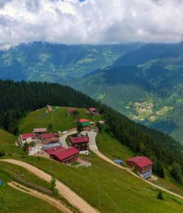 eine Gruppe von Gebäuden auf einem Hügel mit Bergen in der Unterkunft Kalispera Apart Otel in Uzungöl