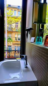 baño con lavabo y ventana en HOTEL de la POSTE, en Esch-sur-Alzette