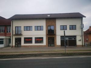 a white building with red signs in the windows at Zen in Tălmaciu