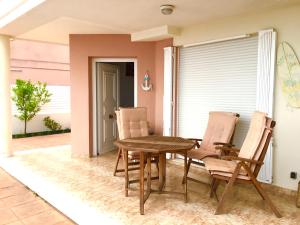 Une table et des chaises en bois sont disponibles sur la terrasse. dans l'établissement 4 bed house, Private Pool near Beach, à Burriana