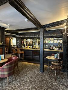 a restaurant with a bar with tables and chairs at The Royal Lion Hotel in Lyme Regis