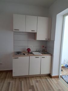 uma cozinha com armários brancos e um lavatório em Villa Ika em Ploče
