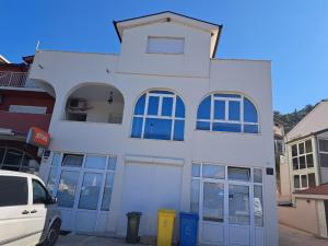 a white building with blue doors and windows at Villa Ika in Ploče