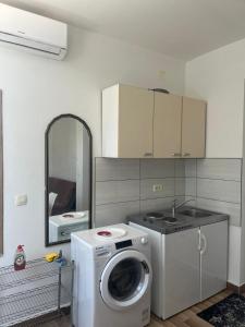 uma cozinha com uma máquina de lavar roupa e um espelho em Villa Ika em Ploče