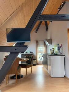 a kitchen with a wooden ceiling and a kitchen with a table at Ferienwohnung an der Brigach in Donaueschingen