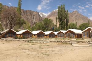a row of wooden huts with mountains in the background at Ldazes Camp in Hundar