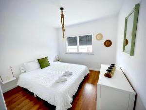 a white bedroom with a white bed and a window at Zambujeira Terrace in Zambujeira do Mar +18 photos