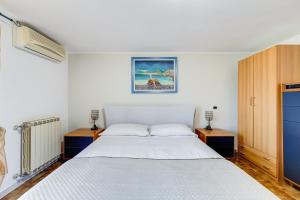 a bedroom with a white bed and two night stands at HomeSweetHome near Rome in Monterotondo