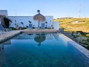 a swimming pool with blue water in front of a house at Très belle villa avec piscine et vue incroyable sur mediterannée (DAR NAIM) in Tangier