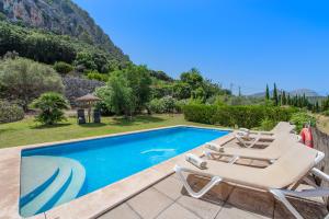 a swimming pool with two lounge chairs and a swimming pool at Coster Puig in Pollença