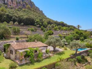 an aerial view of a house with a swimming pool and a mountain at Coster Puig in Pollença