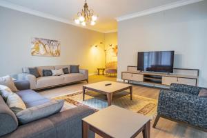 Verula City Apartments في طرابزون: غرفة معيشة مع أريكة وتلفزيون