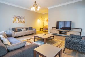 Una sala de estar con un sofá y un televisor. en Verula City Apartments, en Trabzon