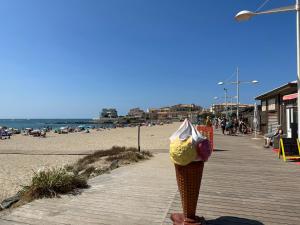 an ice cream cone on a boardwalk next to the beach at L'Acropole in Cap d'Agde