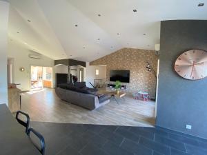 a large living room with a large clock on the wall at Boost Your Immo Corse Solenzara Tozza Alta 819 in Le Pont du Travo