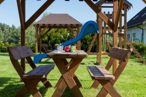 a picnic table and two chairs in a playground at Holiday House Neptun by Renters in Kołczewo