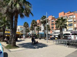 une rue de la ville avec des palmiers et des bâtiments dans l'établissement L'Acropole, au Cap d'Agde