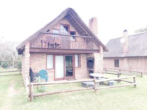 a brick house with a deck and a table in the yard at Kragga Kamma Game Park in Port Elizabeth