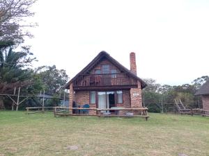 a small brick house with a porch on a field at Kragga Kamma Game Park in Port Elizabeth