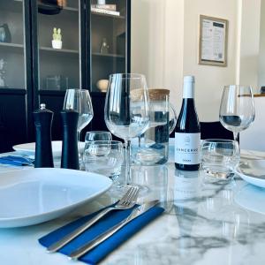 a table with glasses and a bottle of wine at "Le Theodore" Appartement charmant proche gare avec place de parking devant, quartier très calme in Nevers