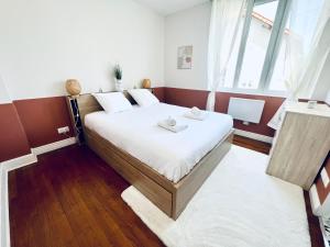 a bedroom with a bed and a large window at "Le Theodore" Appartement charmant proche gare avec place de parking devant, quartier très calme in Nevers +16 photos