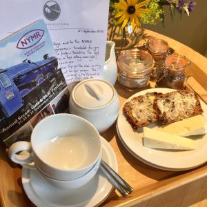 a table with a plate of food and a cup of coffee at Grove House Levisham in Pickering