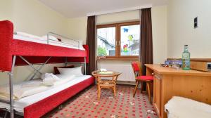 奧夫特爾施旺的住宿－Landhotel Alphorn，一间卧室配有两张双层床和一张书桌