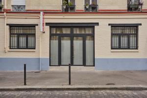 um edifício com portas de vidro e janelas numa rua em Appartement Coeur Montmartre by Studio prestige em Paris