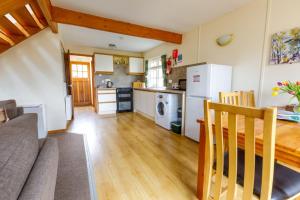 a kitchen and living room with a couch and a table at Pheasant Lodge in Tomich