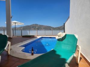 einen Pool mit einem Tisch und einer Flasche Wein in der Unterkunft Villa Esperanza - Canillas de Albaida in Canillas de Albaida