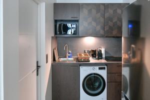 uma cozinha com uma máquina de lavar roupa e um lavatório em Montmartre Charme et Élégance près du Sacré-Cœur em Paris