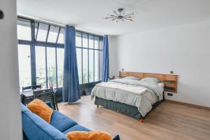 ein Schlafzimmer mit einem Bett und einem blauen Sofa in der Unterkunft Montmartre Charme et Élégance près du Sacré-Cœur in Paris