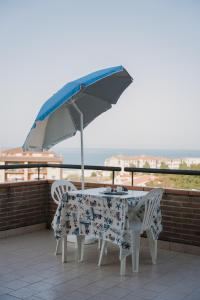 uma mesa e cadeiras com um guarda-sol numa varanda em STELLA DI MARE em Marina di San Vito