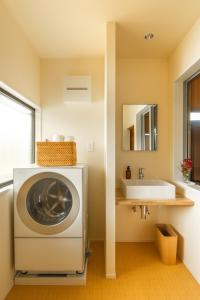 eine Waschmaschine im Bad mit Waschbecken in der Unterkunft Temple Hotel 南アルプス法源寺 in Minami Alps