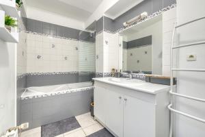 un baño con bañera y lavabo en Duplex with terrace and parking in Villejuif, en Villejuif