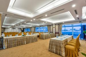 a banquet hall with tables and chairs and windows at La Sapinette Hotel Dalat in Da Lat