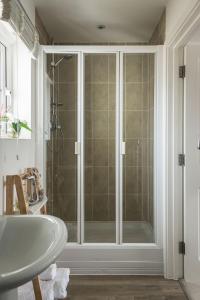 a bathroom with a shower with a glass door at Pebbles in Camber