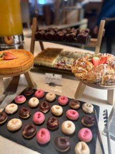 a tray of donuts and a tray of pastries at Hotel Auwirt Zentrum in Saalbach-Hinterglemm