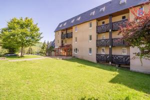an apartment building with a lawn in front of it at A 4, découverte de la montagne - 80m des pistes in Val Louron