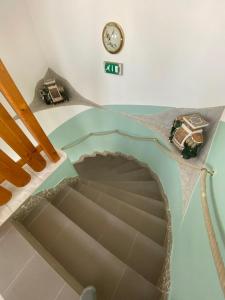 uma vista para uma escada com um relógio na parede em Pension Lizzi em Viena