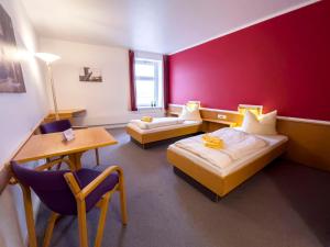 a hotel room with two beds and a table and chairs at Jugendherberge Lauenburg Zündholzfabrik in Hohnstorf