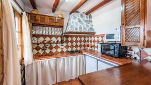 una cucina con ripiani in legno e forno a microonde di Casa El Carril Benalauria by Ruralidays a Benalauría